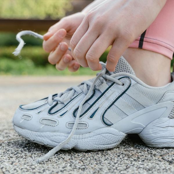 Close-up of running shoes on a wooden floor, ready for a workout.