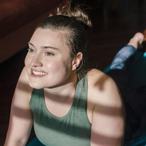 Smiling person stretching after a light home workout session.
